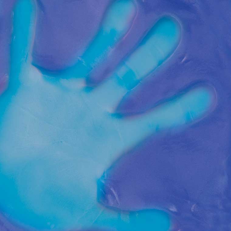 Close up detail of heat sensitive purple putty with blue hand print in the middle.