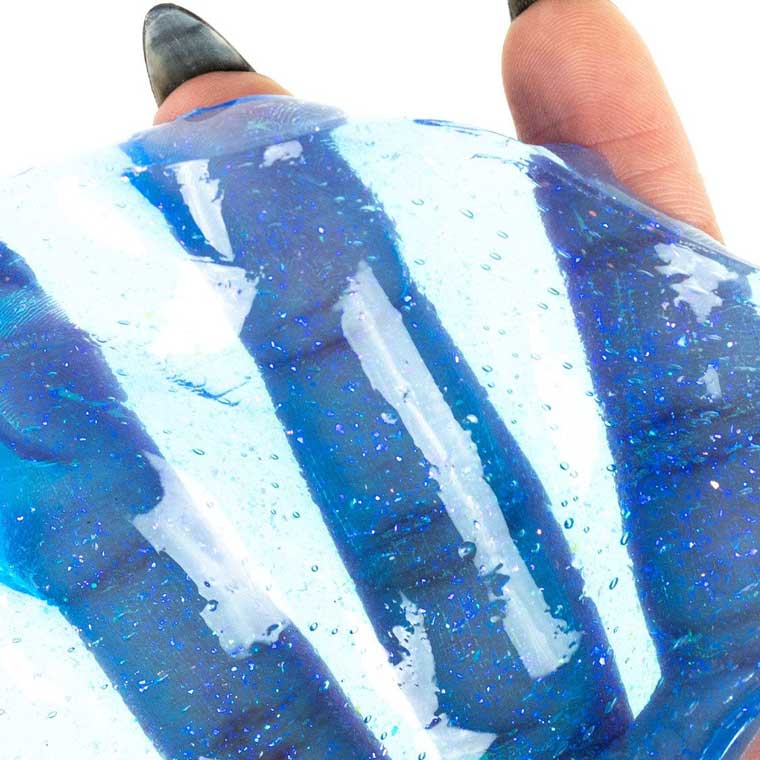 Close up of hand holding clear blue putty.