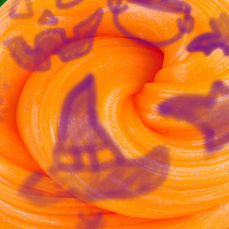 Close up of orange putty with purple lines drawn on it. 