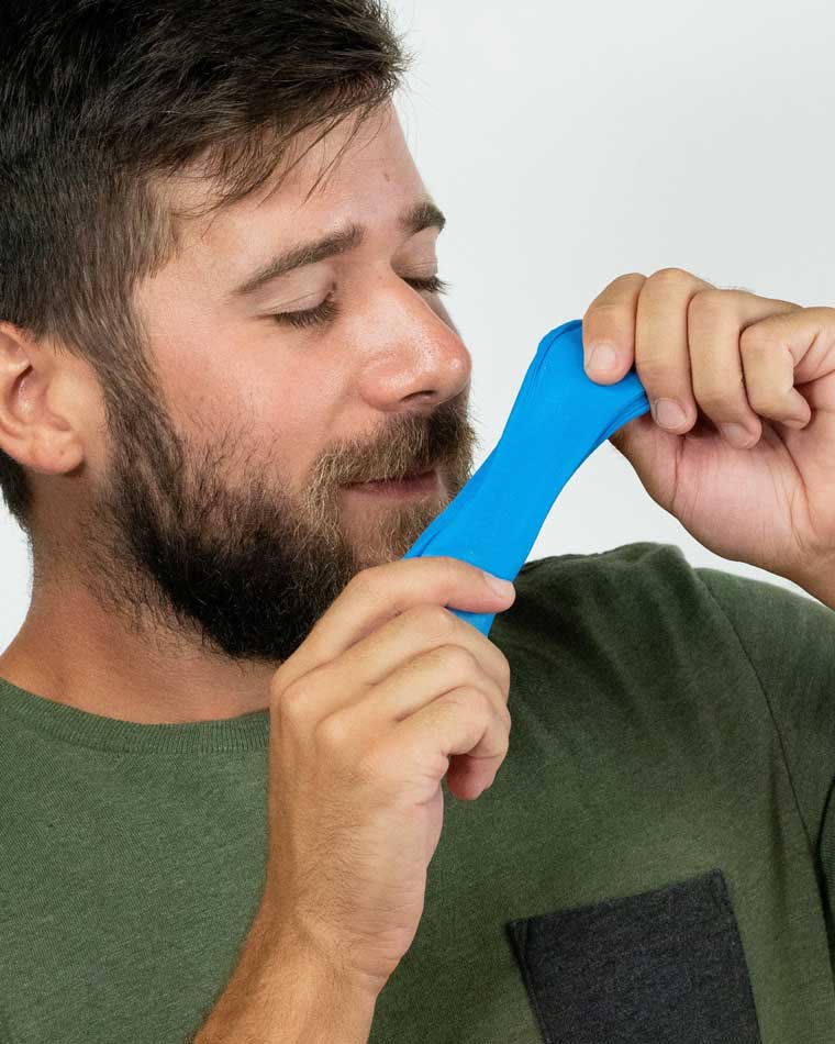 Man holding and smelling blue scented putty.